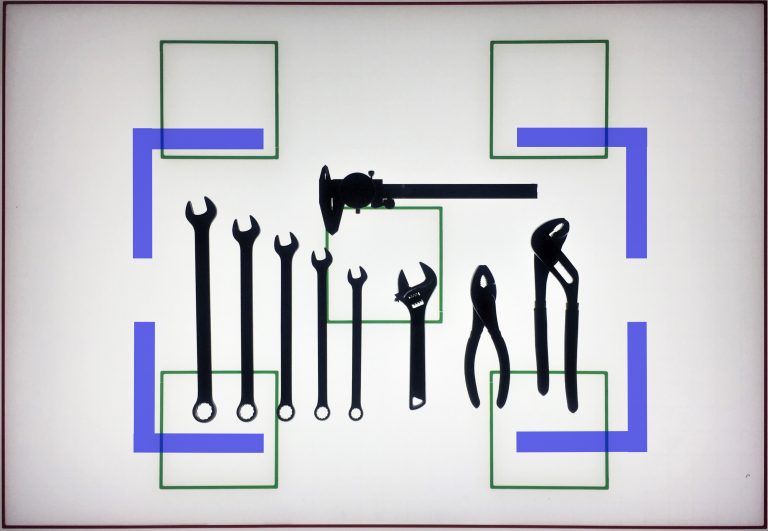 Tools laid out on a light box grid, ready to be photographed